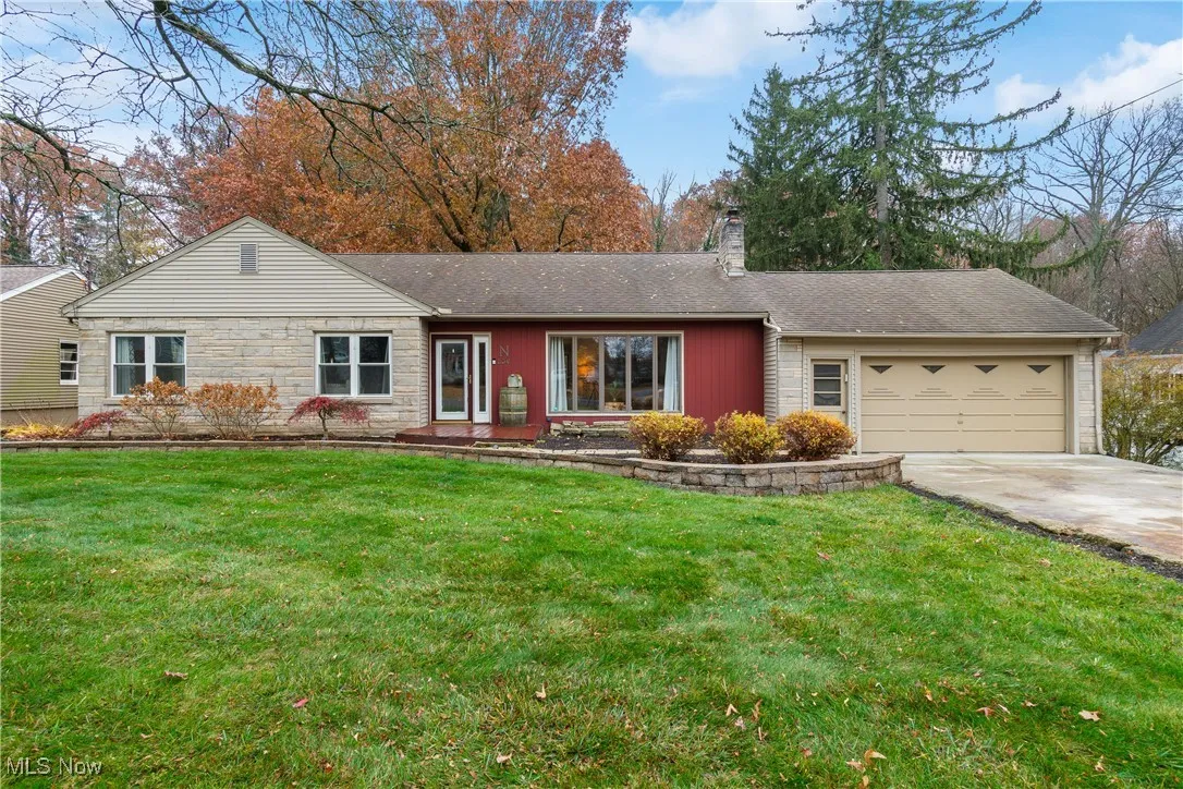 Ranch-style home with a front lawn, concrete driveway, a shingled roof, a chimney, and a garage