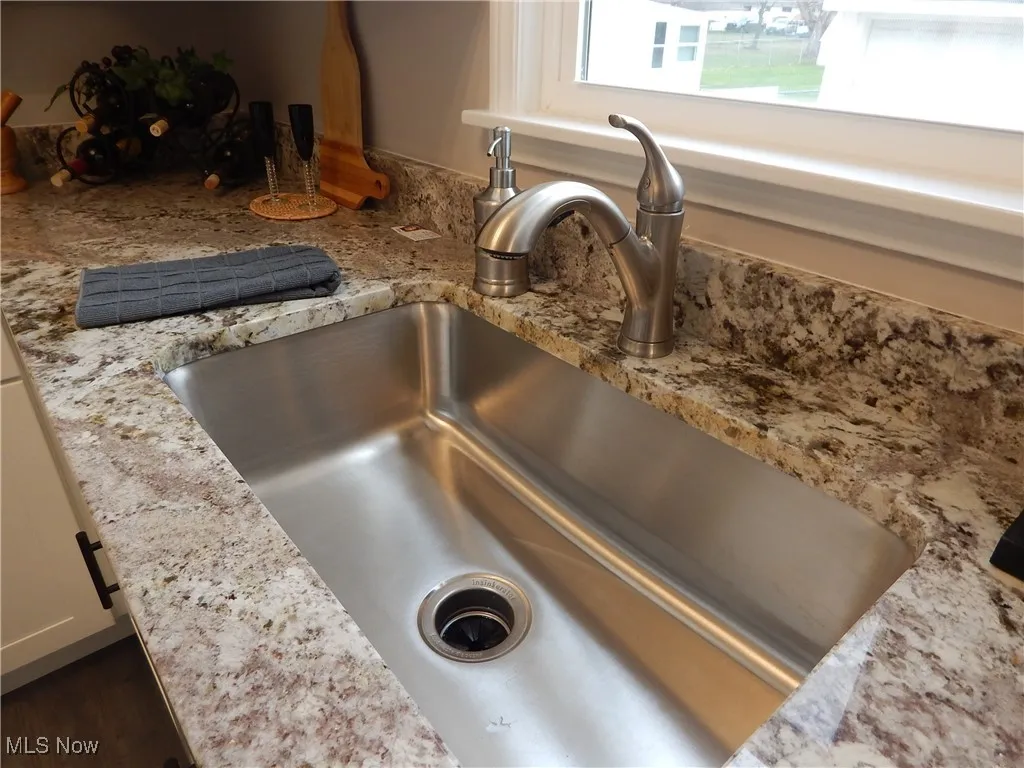 Kitchen view of upscaled Granite counters and Stainless-steel Sink & fixtures.