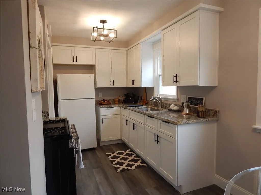 Kitchen featuring all new, soft close white Cabinetry, gas Stove, Microwave & gorgeous Granite Counters with brand new fixtures.