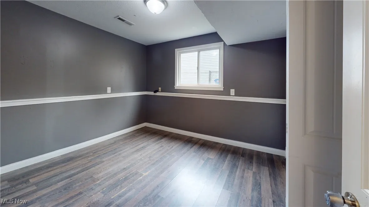 Unfurnished room with light wood finished floors and baseboards