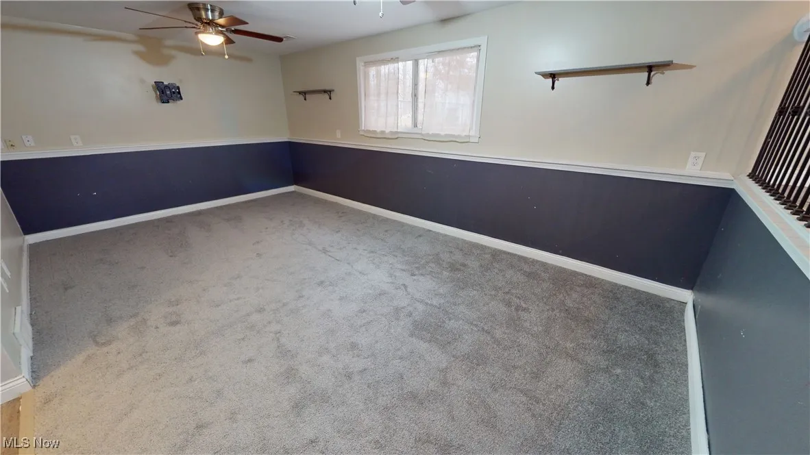 Empty room with ceiling fan and carpet flooring