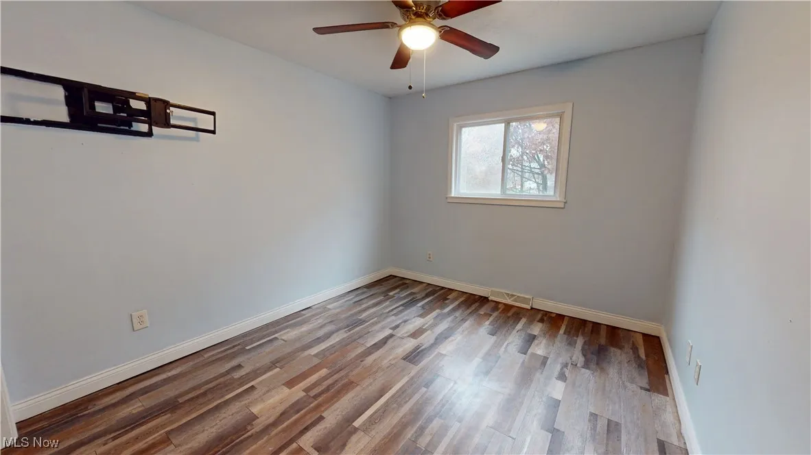 Spare room with wood finished floors and ceiling fan