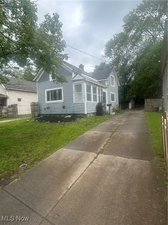 Bungalow-style house featuring driveway and a chimney