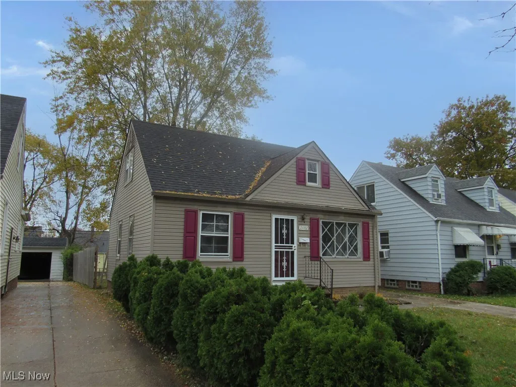 Cape cod-style house featuring roof with shingles