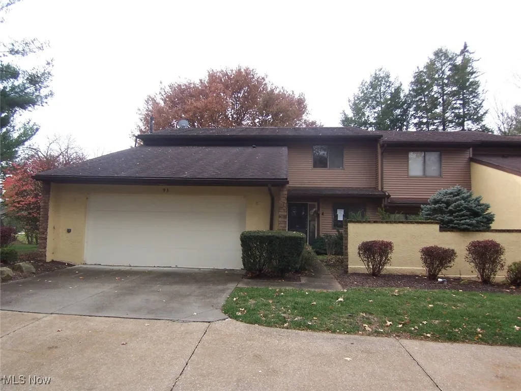 View of front of property featuring concrete driveway, an attached garage, and roof with shingles