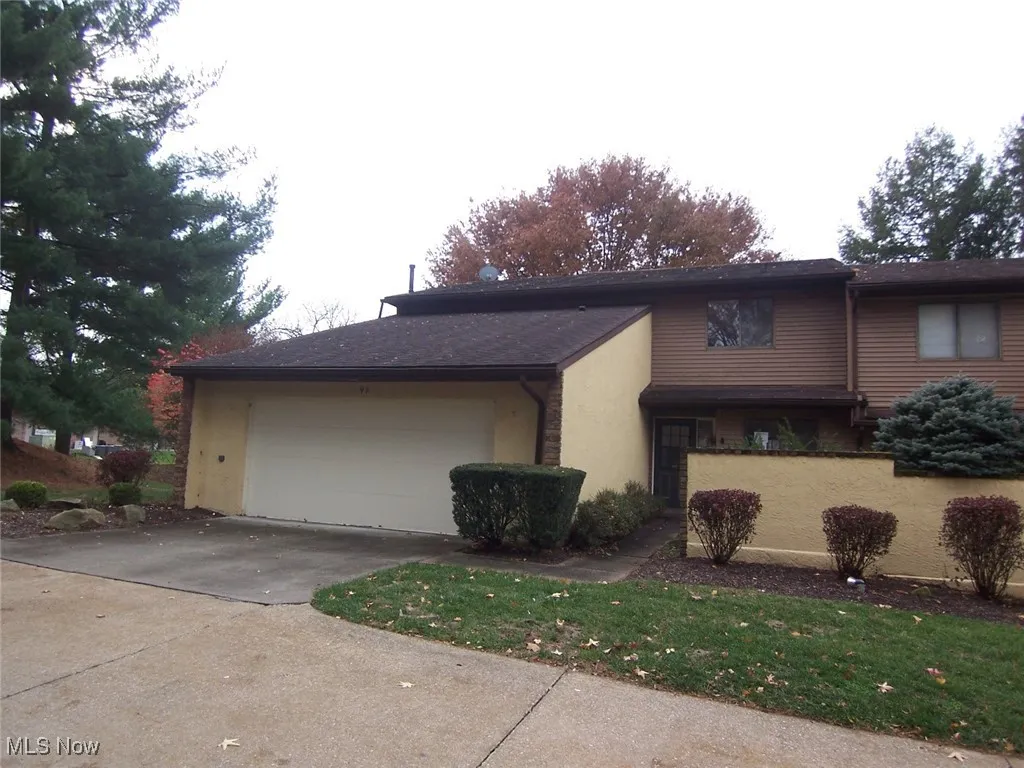 View of property exterior featuring driveway, stucco siding, and an attached garage