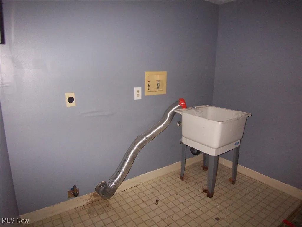 Laundry area with hookup for a washing machine and tile patterned flooring