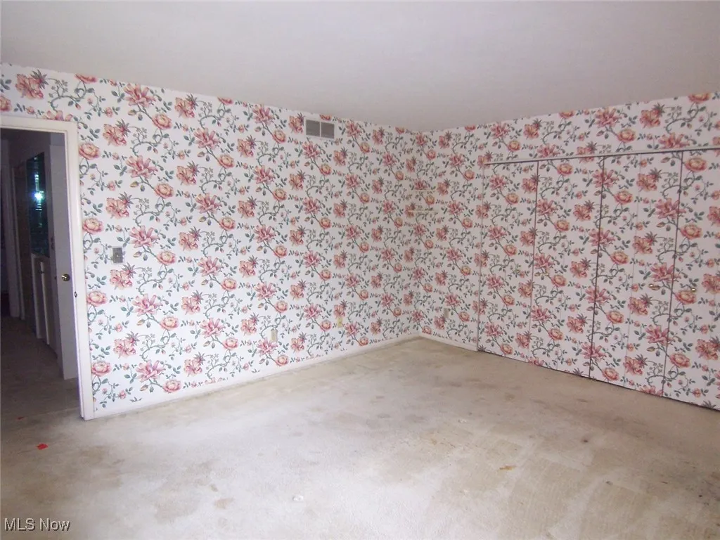 Unfurnished room featuring wallpapered walls and light carpet