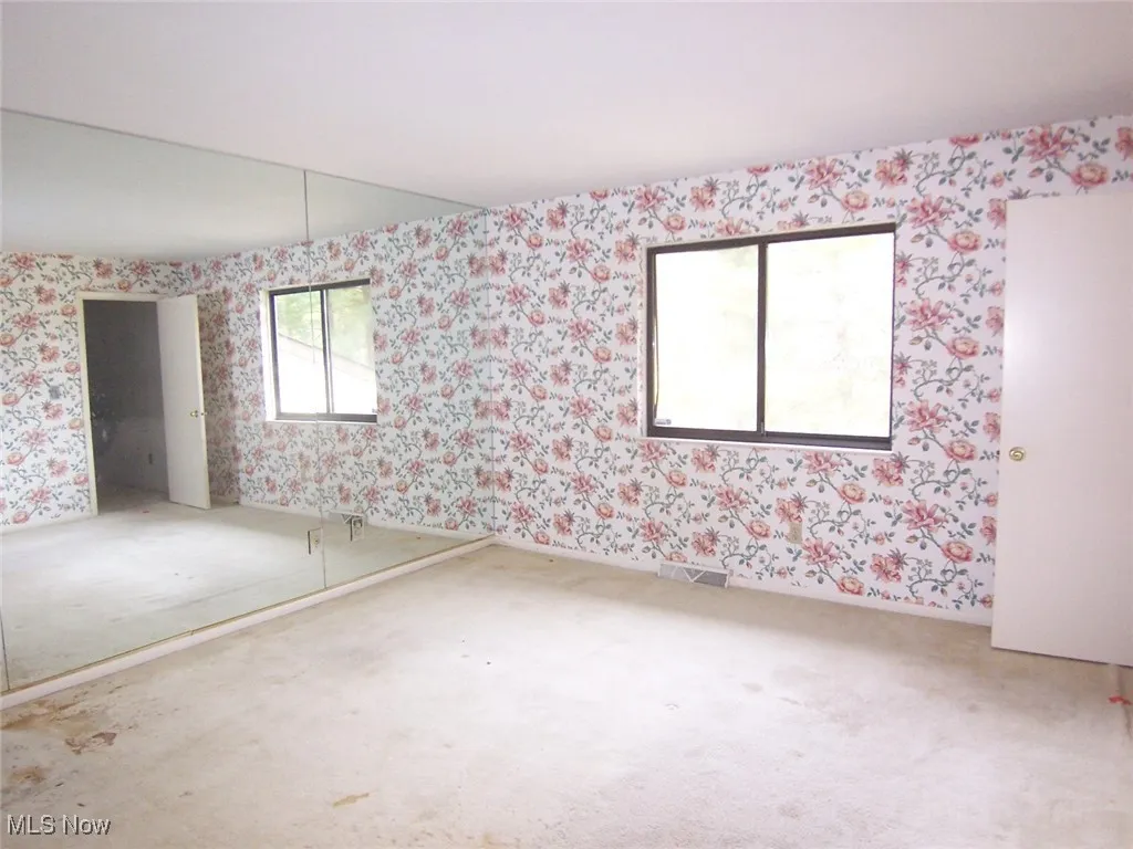 Unfurnished room with wallpapered walls