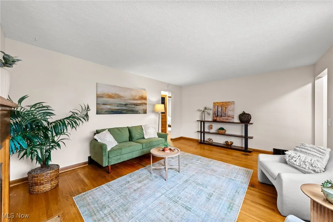 Living area with light wood-type flooring and a textured ceiling
