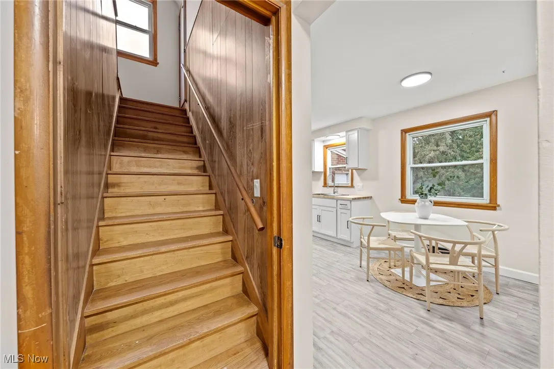 Stairway with plenty of natural light and wood finished floors