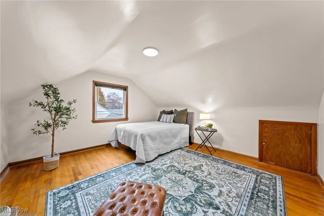 Bedroom featuring hardwood / wood-style floors and vaulted ceiling