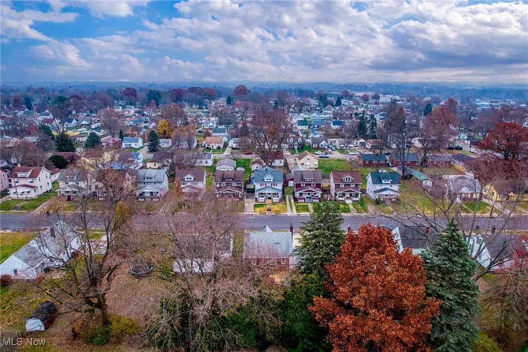 Aerial view of property and surrounding area featuring nearby suburban area