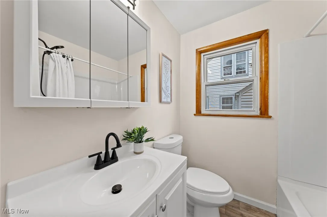 Full bathroom featuring vanity, shower / tub combo, and wood finished floors