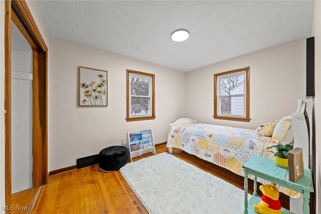 Bedroom featuring a textured ceiling, a closet, and hardwood / wood-style floors