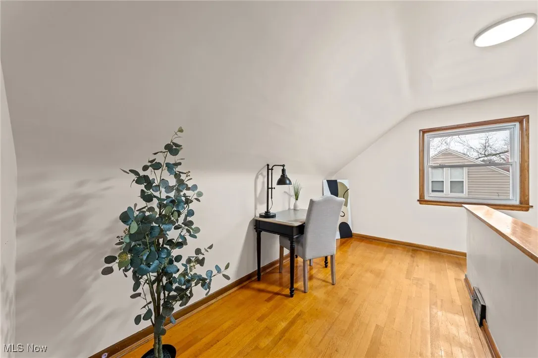 Office featuring light wood-style floors and vaulted ceiling