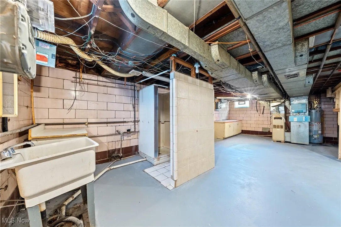 Unfinished basement with gas water heater and heating unit