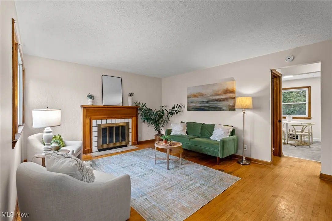 Living room featuring a fireplace, a textured ceiling, and hardwood / wood-style floors