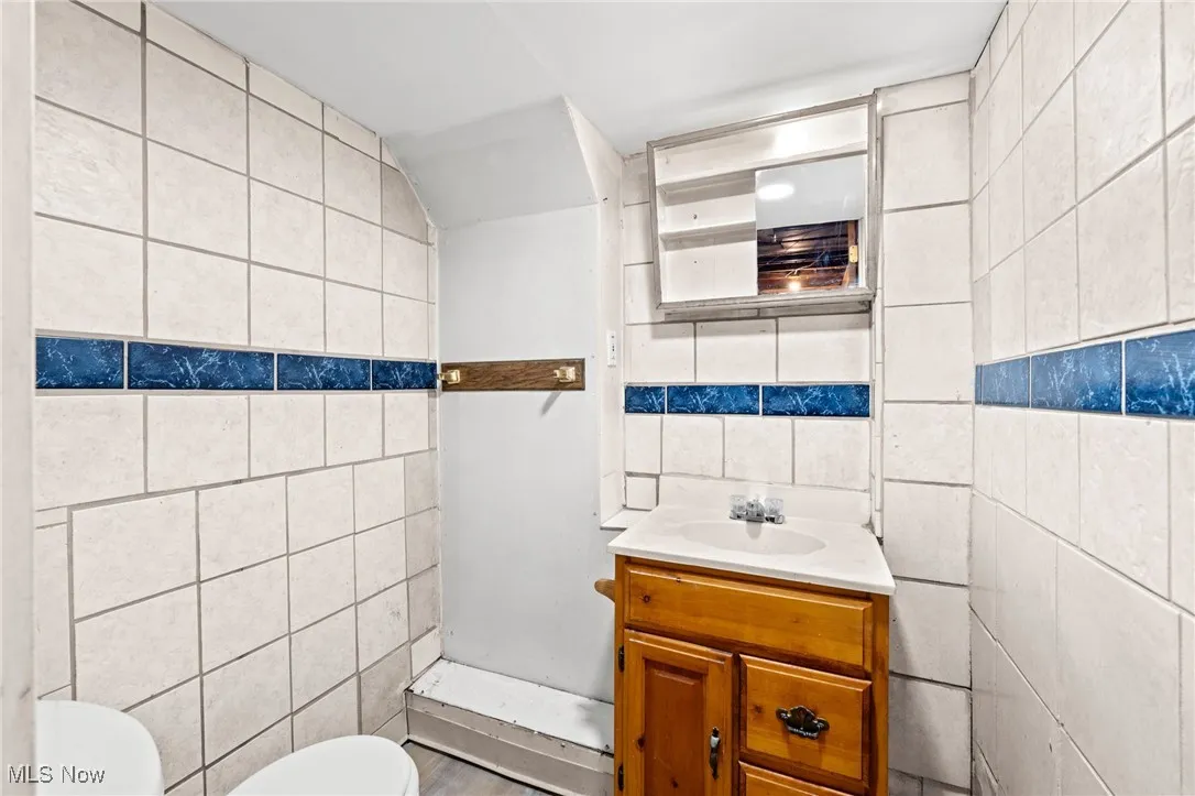 Bathroom featuring tile walls and vanity