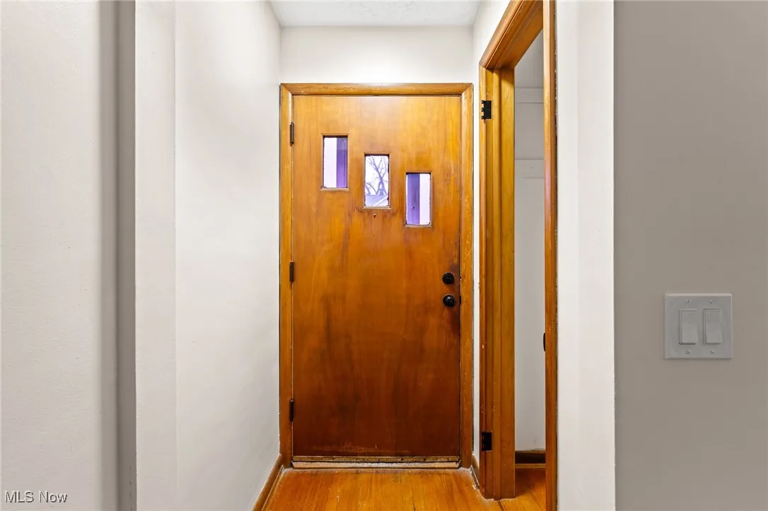 Doorway to outside with wood finished floors and baseboards