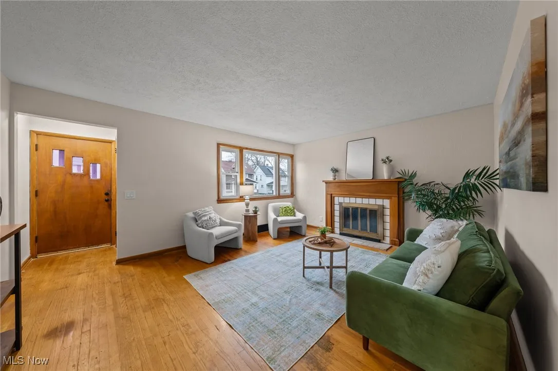 Living area featuring a textured ceiling, a fireplace, and hardwood / wood-style flooring