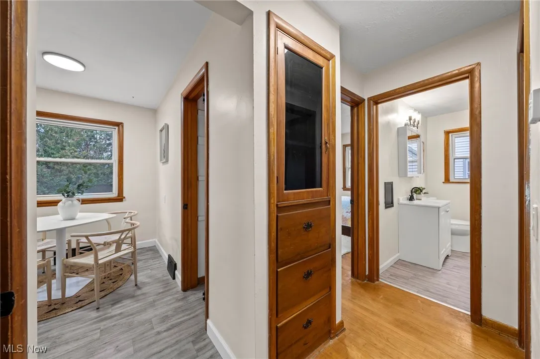 Corridor featuring light wood-style flooring and baseboards