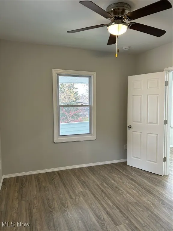Empty room with wood finished floors and ceiling fan