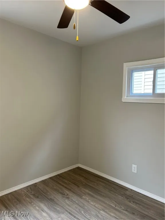 Bed room with dark wood finished floors and a ceiling fan