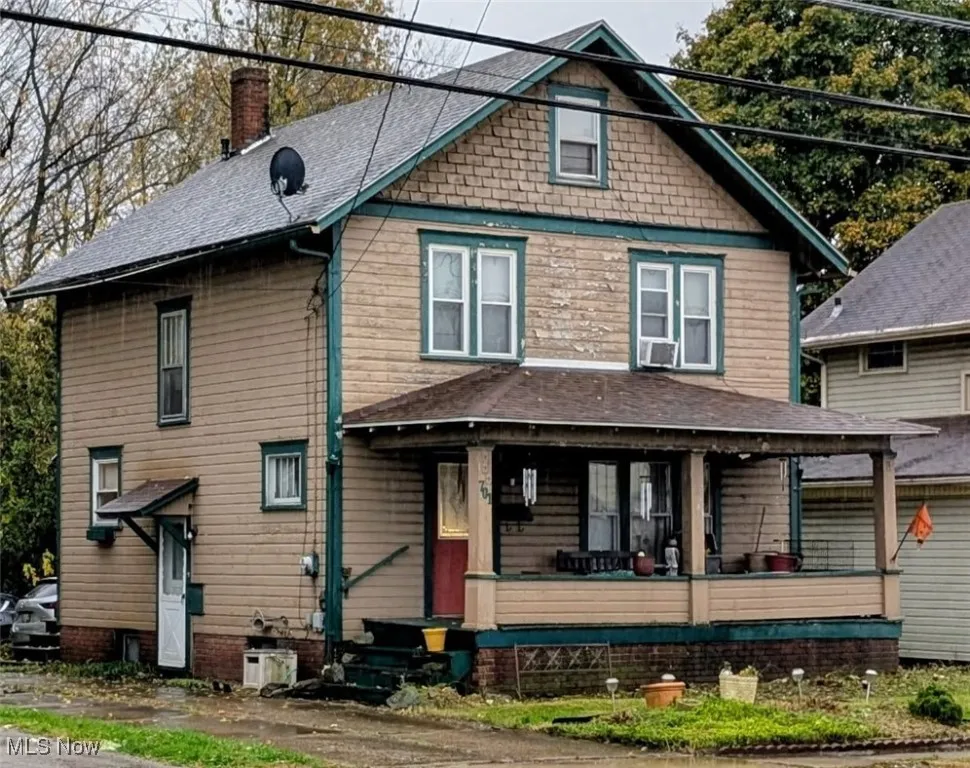 Traditional style home with a chimney, covered porch, and roof with shingles