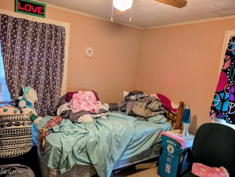 Bedroom with ceiling fan and ornamental molding