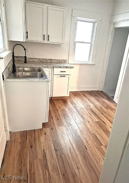 Kitchen with white cabinets, light countertops, and light wood-type flooring