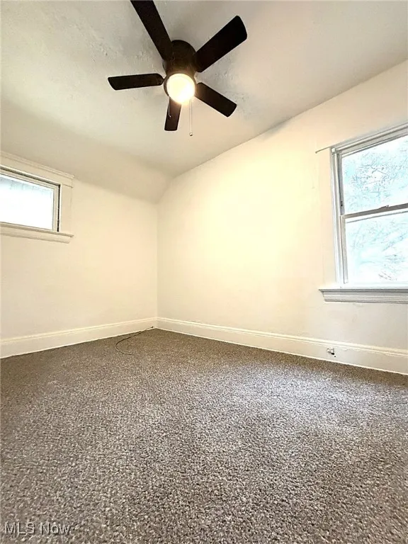 Unfurnished room featuring a textured ceiling and vaulted ceiling