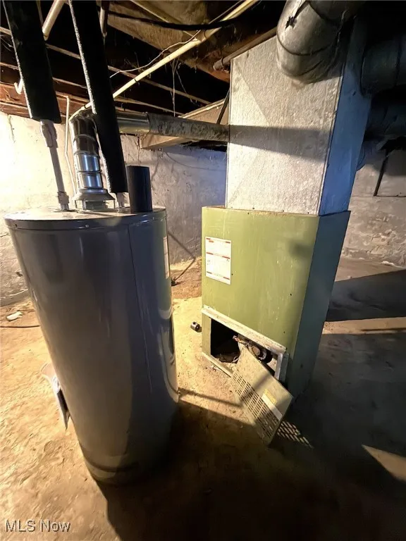 Utility room featuring water heater and heating unit