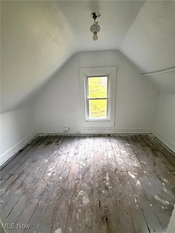 Bonus room with vaulted ceiling and hardwood / wood-style flooring