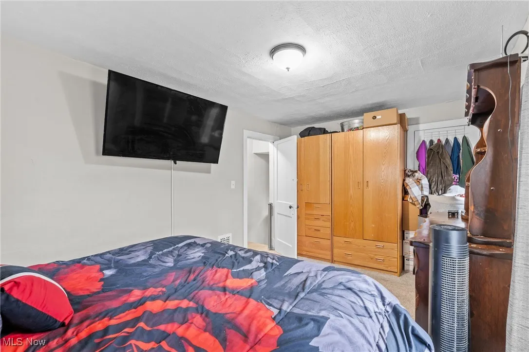Bedroom featuring a textured ceiling, a closet, and carpet flooring