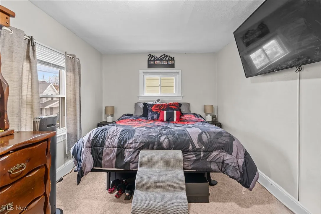 Carpeted bedroom featuring multiple windows