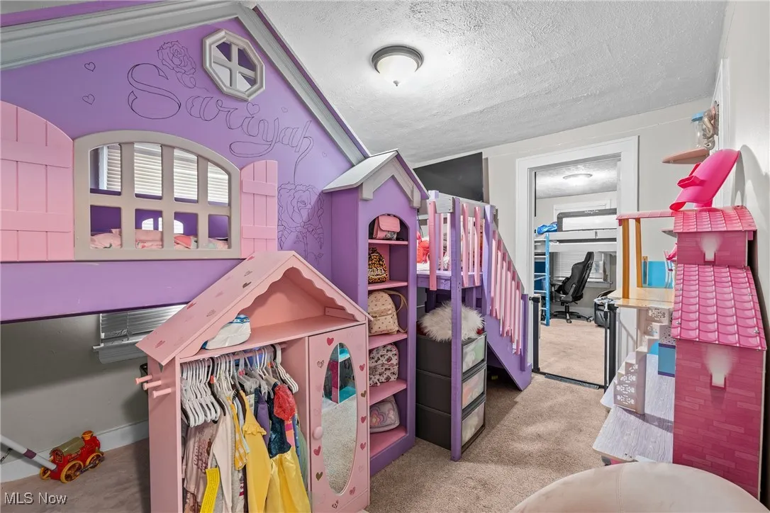 Bedroom with light colored carpet and a textured ceiling