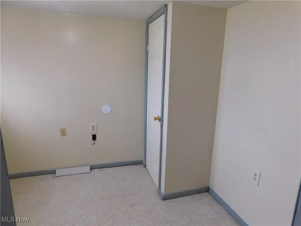 Laundry area with light floors and baseboards