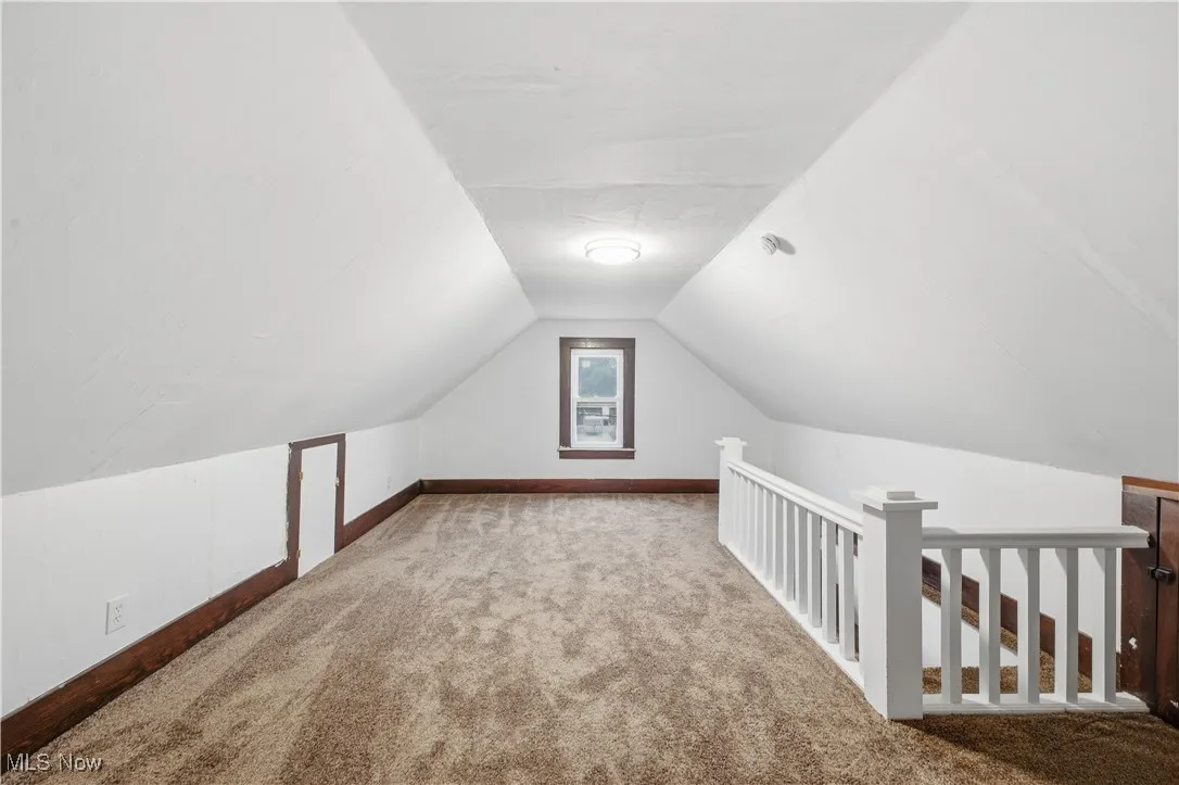 Additional living space featuring lofted ceiling and carpet floors