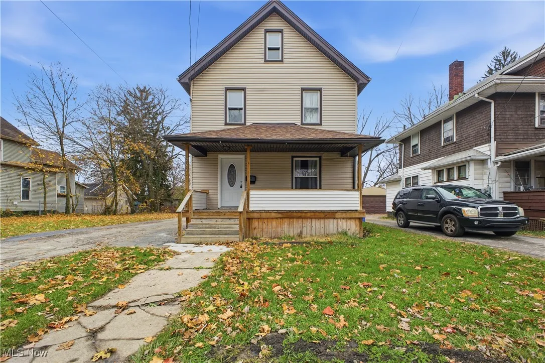 Traditional style home featuring a porch, a front lawn, and roof with shingles