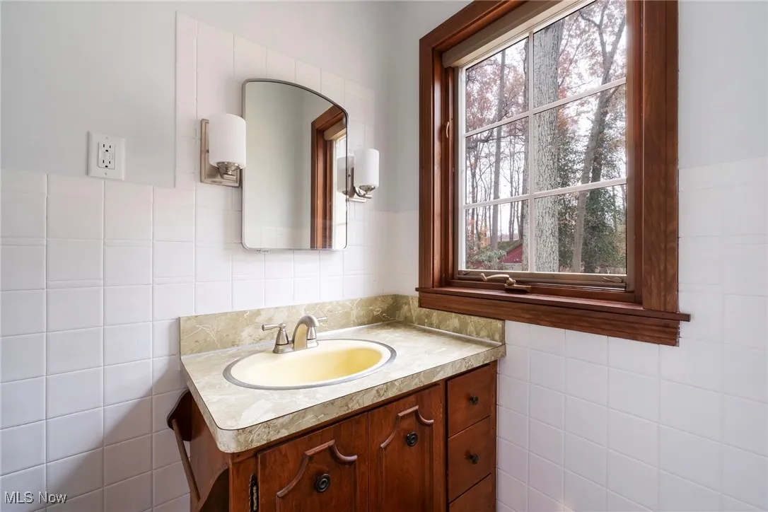 Bathroom featuring tile walls and vanity