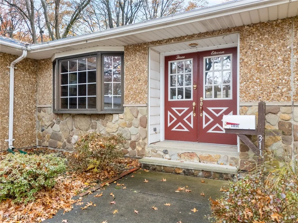 Entrance to property featuring stone siding and french doors