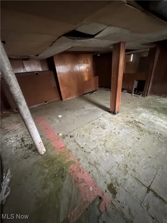 Unfinished basement featuring wood walls