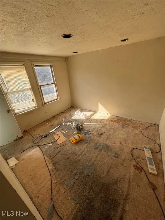 Empty room featuring a textured ceiling