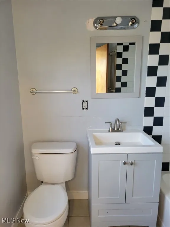 Bathroom with vanity, curtained shower, and tile patterned flooring