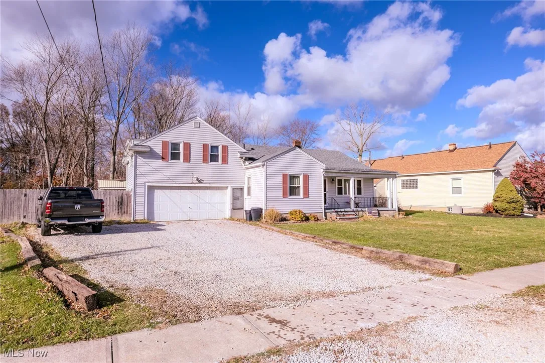 View of front of house featuring driveway, covered porch, and an attached garage