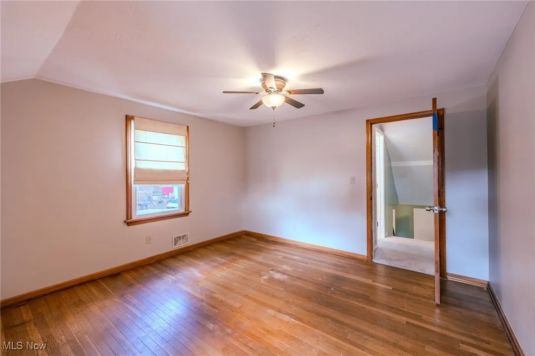 Unfurnished bedroom featuring hardwood / wood-style floors and ceiling fan