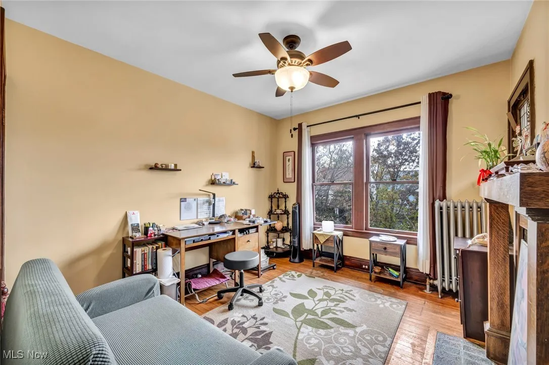 Office featuring radiator, light wood-type flooring, and ceiling fan