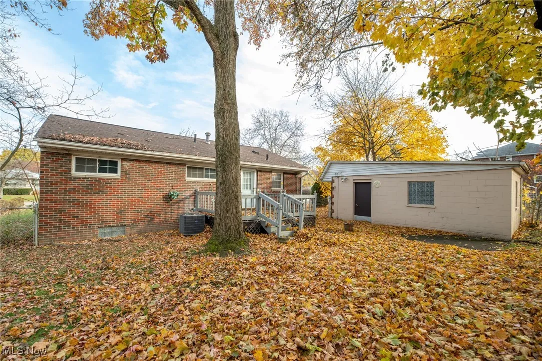 Back of house with brick siding, a deck, and crawl space