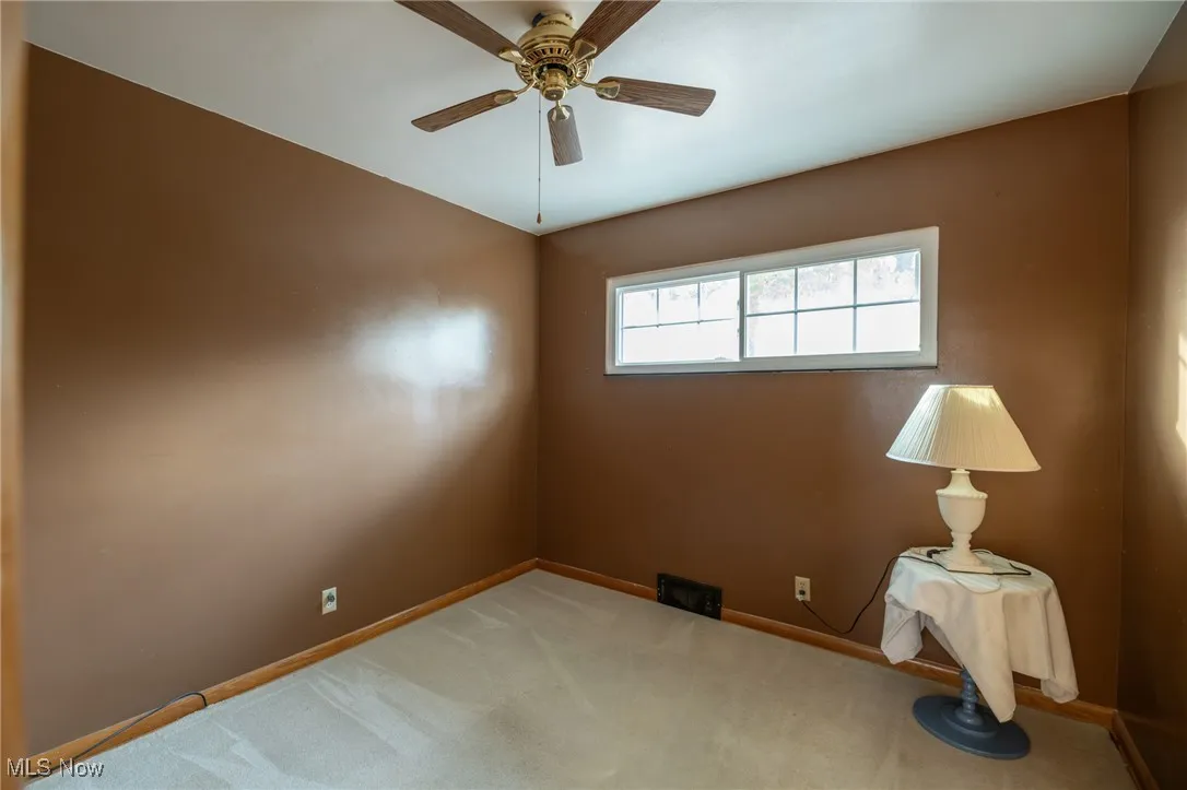 Unfurnished room featuring carpet floors and ceiling fan